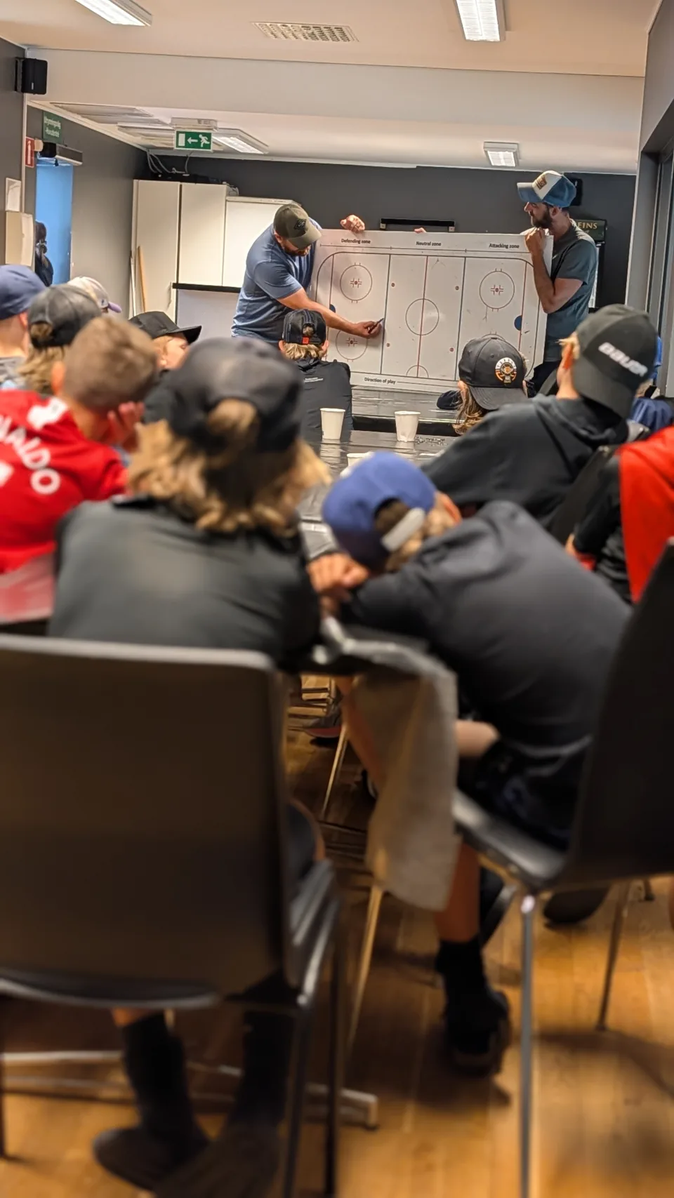 Tränare går igenom en spelövning på taktiktavlan inför gruppen